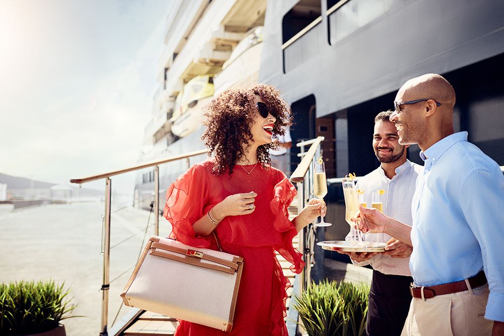 woman boarding ritz yacht with champagne